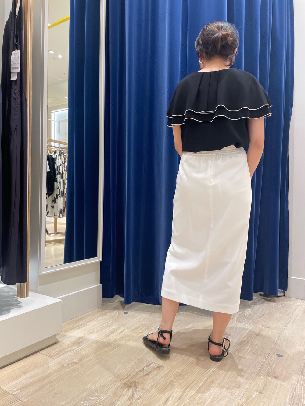 ブラック系のシャツ/ブラウス、ホワイト系のスカートを着用したレディースの夏コーディネートの2枚目の写真