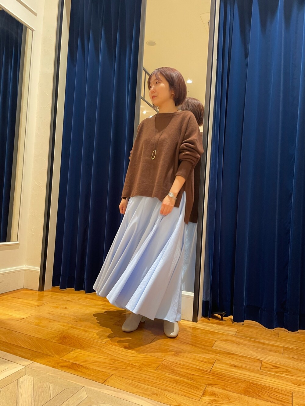 ブラウン系のニット/セーター、ブルー系のスカートを着用したレディースの冬コーディネートの4枚目の写真