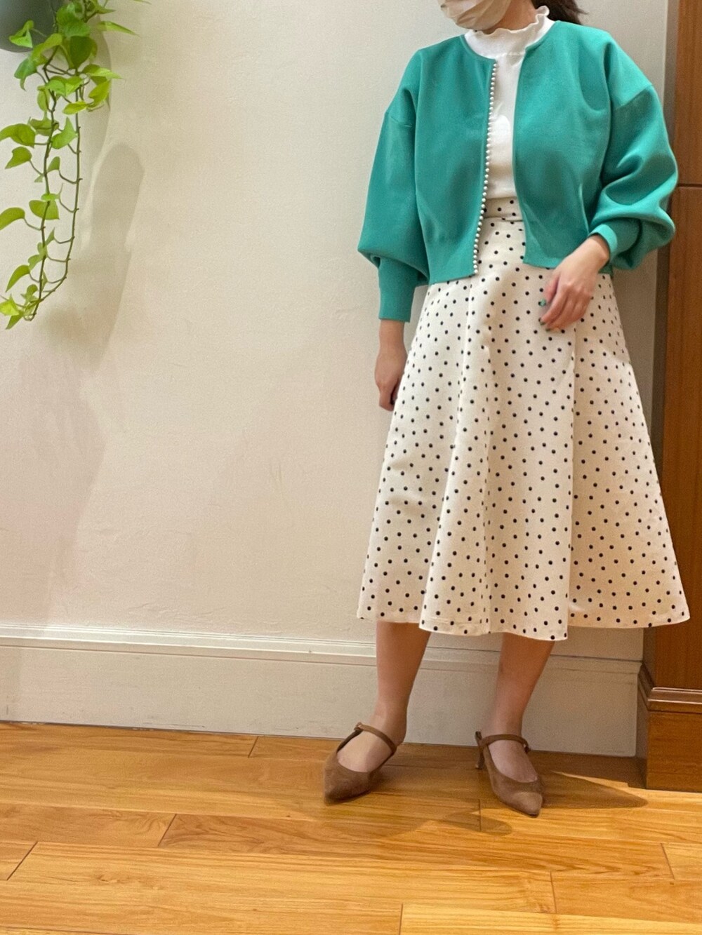 グリーン系のカーディガン/ボレロ、ホワイト系のスカート、ホワイト系のTシャツ/カットソーを着用したレディースの春コーディネートの4枚目の写真