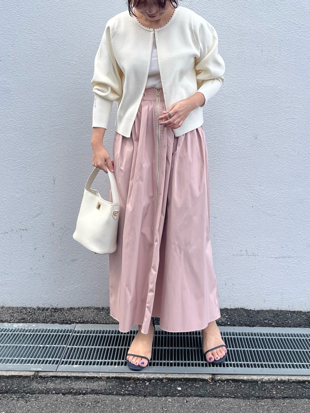 ホワイト系のカーディガン/ボレロ、ピンク系のスカート、オレンジ系のショルダーバッグを着用したレディースの春コーディネートの2枚目の写真