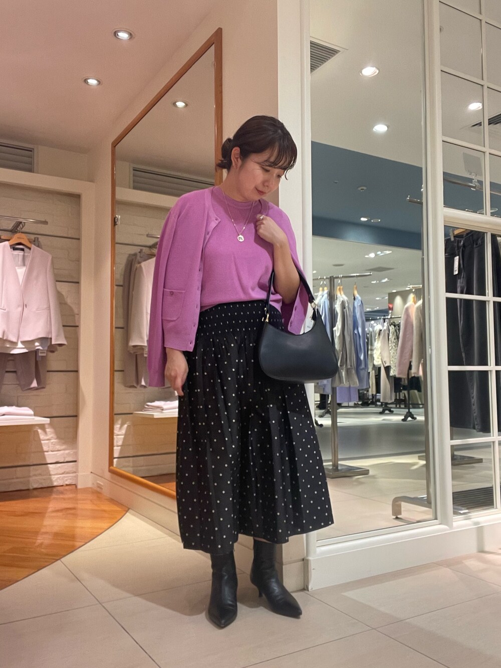 ピンク系のカーディガン/ボレロ、ピンク系のニット/セーター、ブラック系のスカートを着用したレディースの秋コーディネートの2枚目の写真