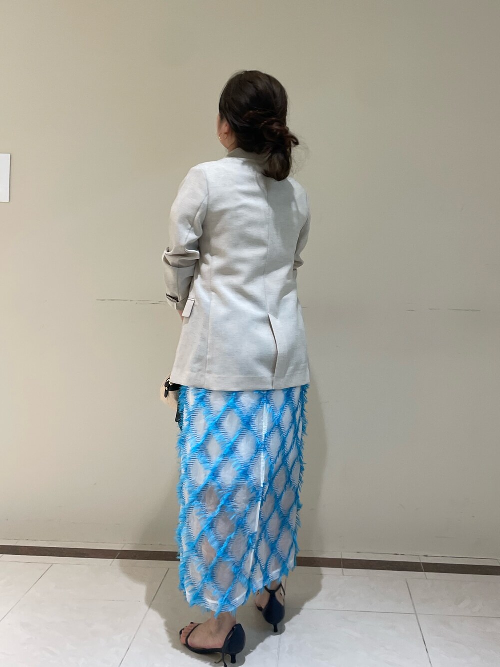 ベージュ系のテーラードジャケット、ブルー系のスカート、ホワイト系のTシャツ/カットソーを着用したレディースの春コーディネートの7枚目の写真