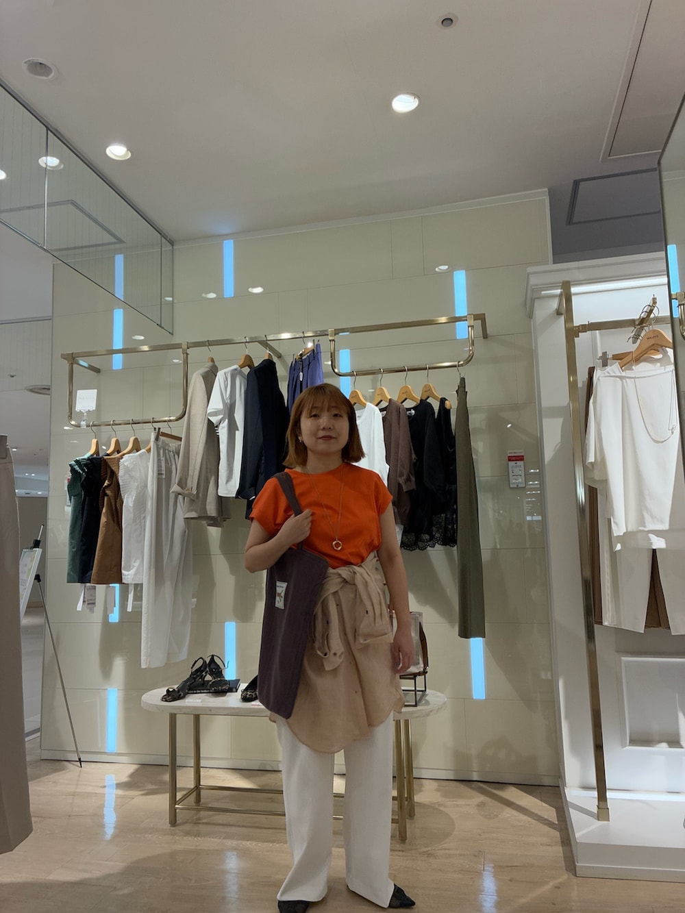 オレンジ系のTシャツ/カットソー、ピンク系のシャツ/ブラウス、ホワイト系のその他パンツを着用したレディースの春コーディネートの5枚目の写真