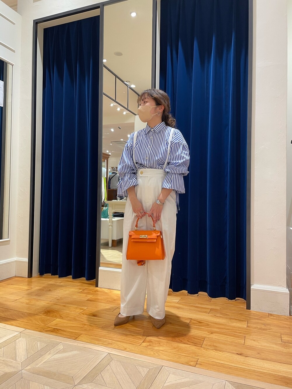 ブルー系のシャツ/ブラウス、ホワイト系のその他パンツ、オレンジ系のショルダーバッグを着用したレディースの春コーディネートの3枚目の写真