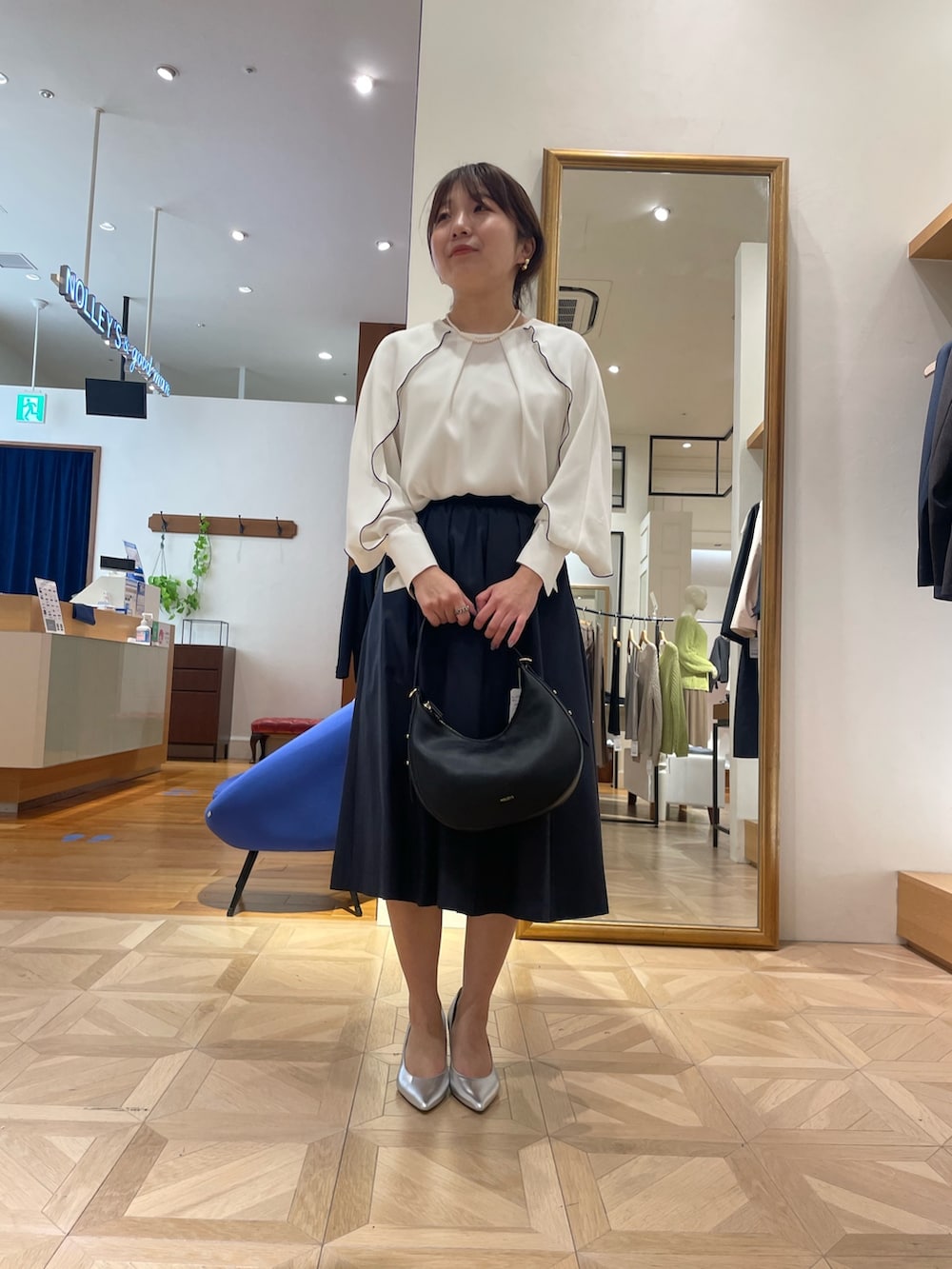 ホワイト系のシャツ/ブラウス、ブルー系のスカート、ブラック系のショルダーバッグを着用したレディースの春コーディネートの2枚目の写真