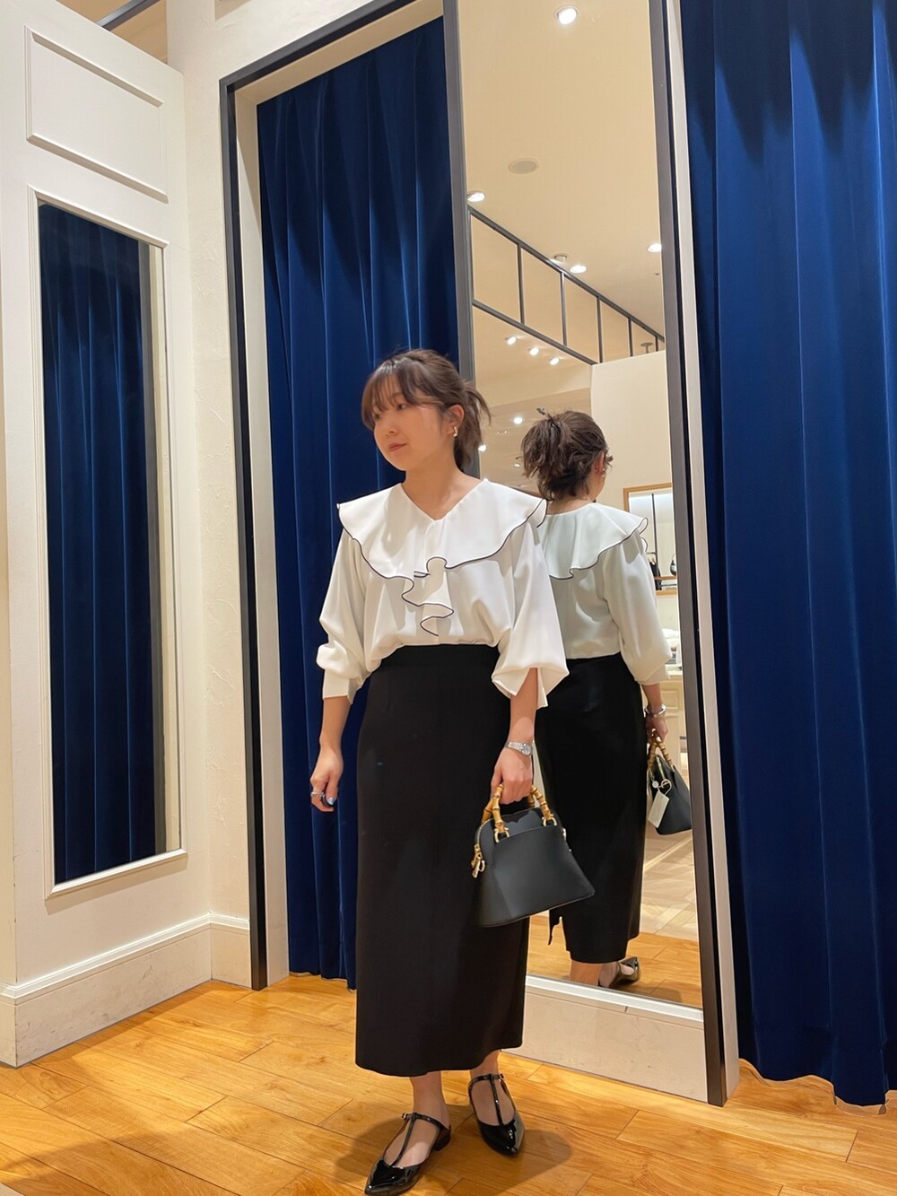 ホワイト系のシャツ/ブラウス、ブラック系のスカート、ゴールド系のパンプスを着用したレディースの春コーディネートの4枚目の写真