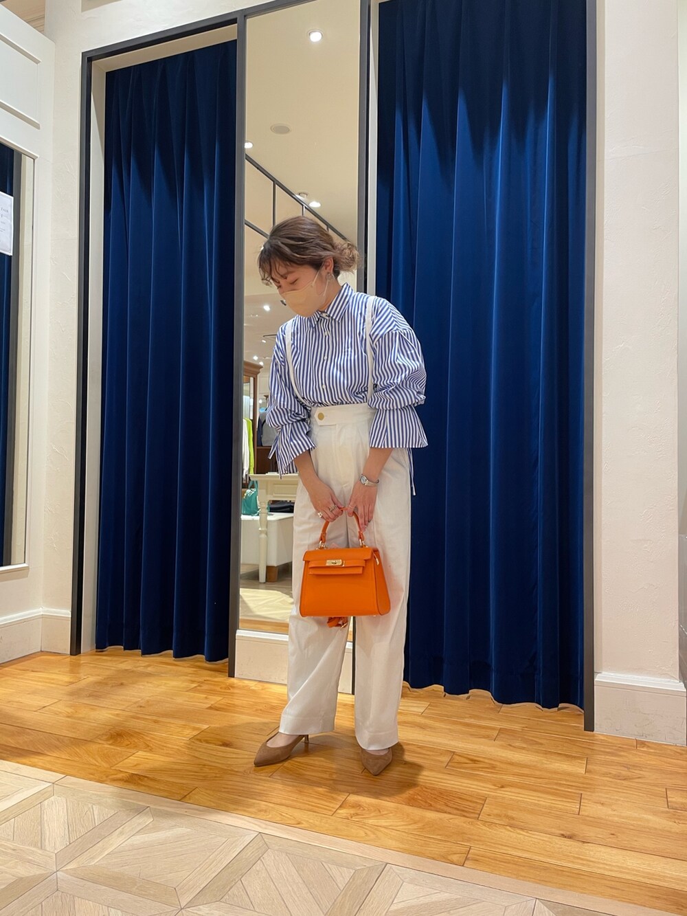 ブルー系のシャツ/ブラウス、ホワイト系のその他パンツ、オレンジ系のショルダーバッグを着用したレディースの春コーディネートの5枚目の写真