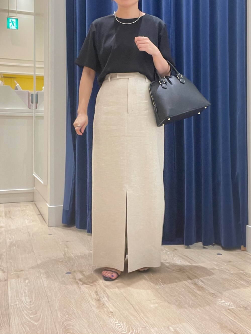 ベージュ系のスカート、ブラック系のシャツ/ブラウス、ブラック系のボストンバッグを着用したレディースの春コーディネートの4枚目の写真
