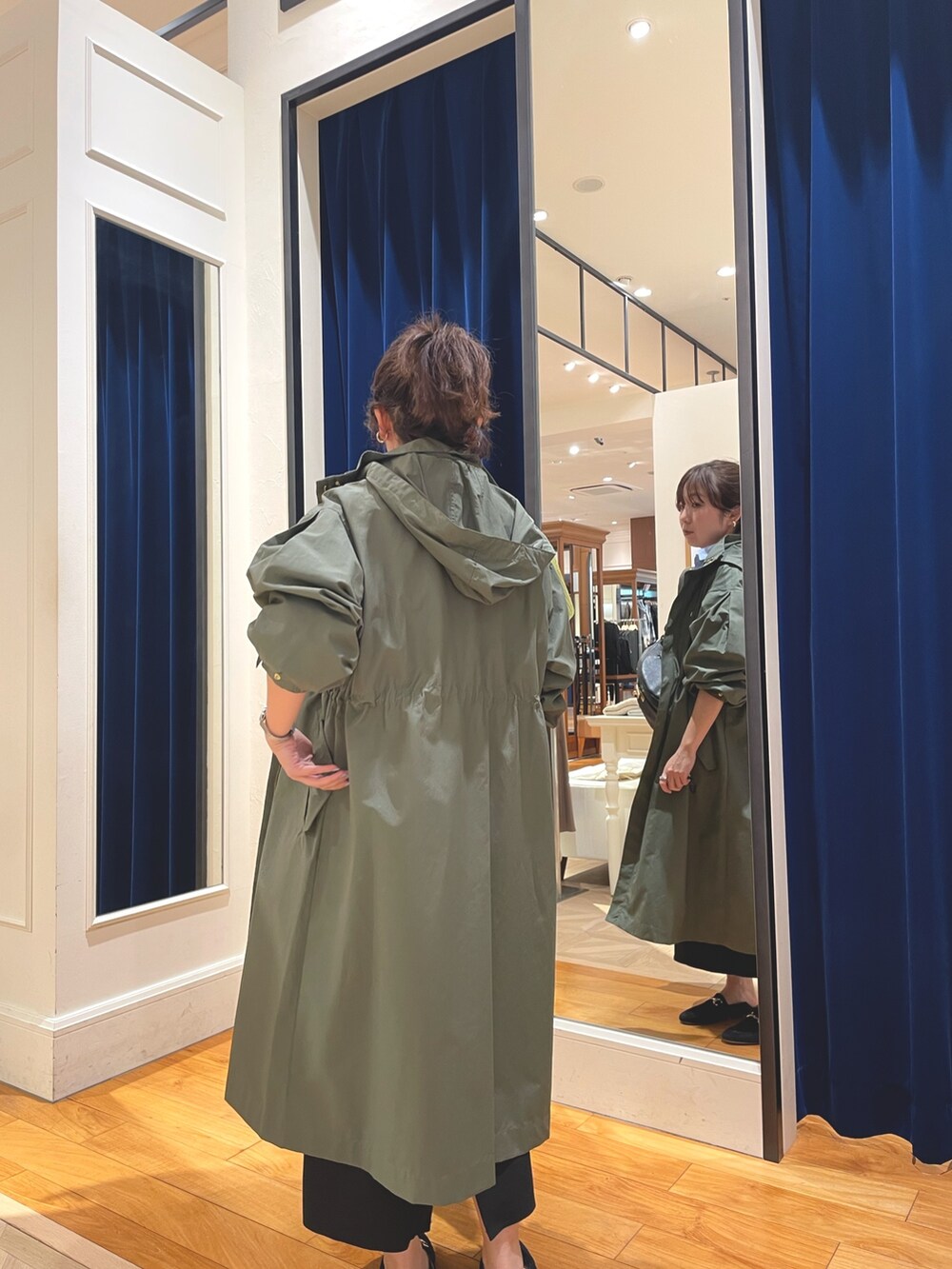 グリーン系のその他アウター、ブラック系のスカート、ブルー系のシャツ/ブラウスを着用したレディースの春コーディネートの5枚目の写真