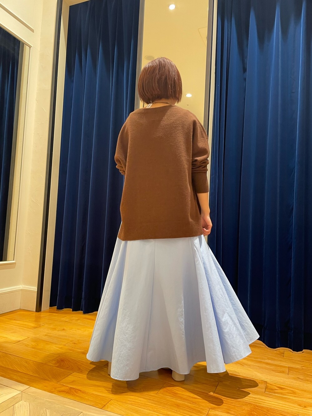 ブラウン系のニット/セーター、ブルー系のスカートを着用したレディースの冬コーディネートの3枚目の写真