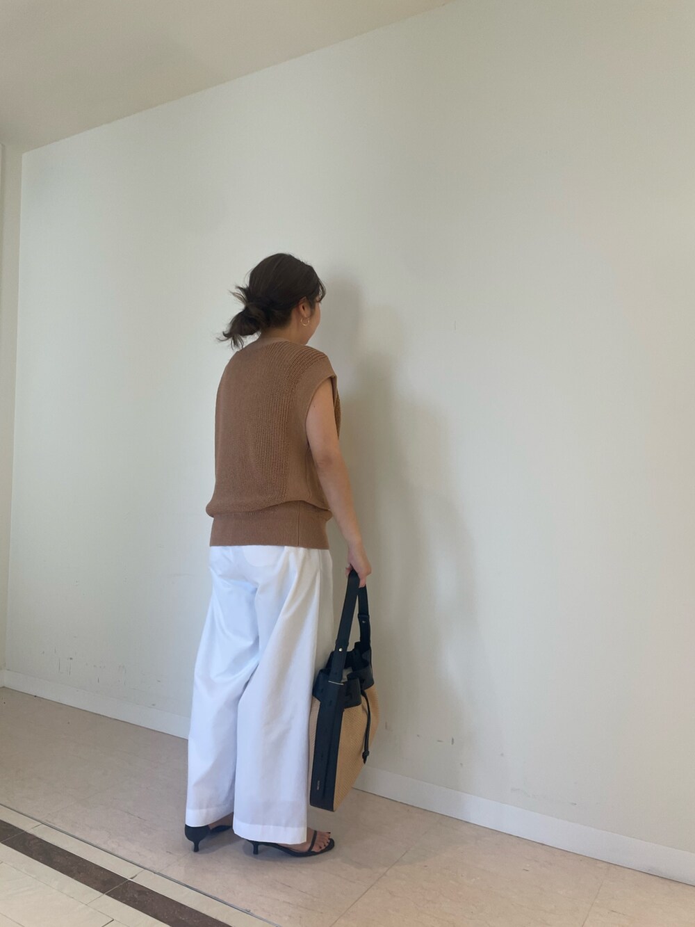 ホワイト系のその他パンツ、イエロー系のベストを着用したレディースの春コーディネートの3枚目の写真