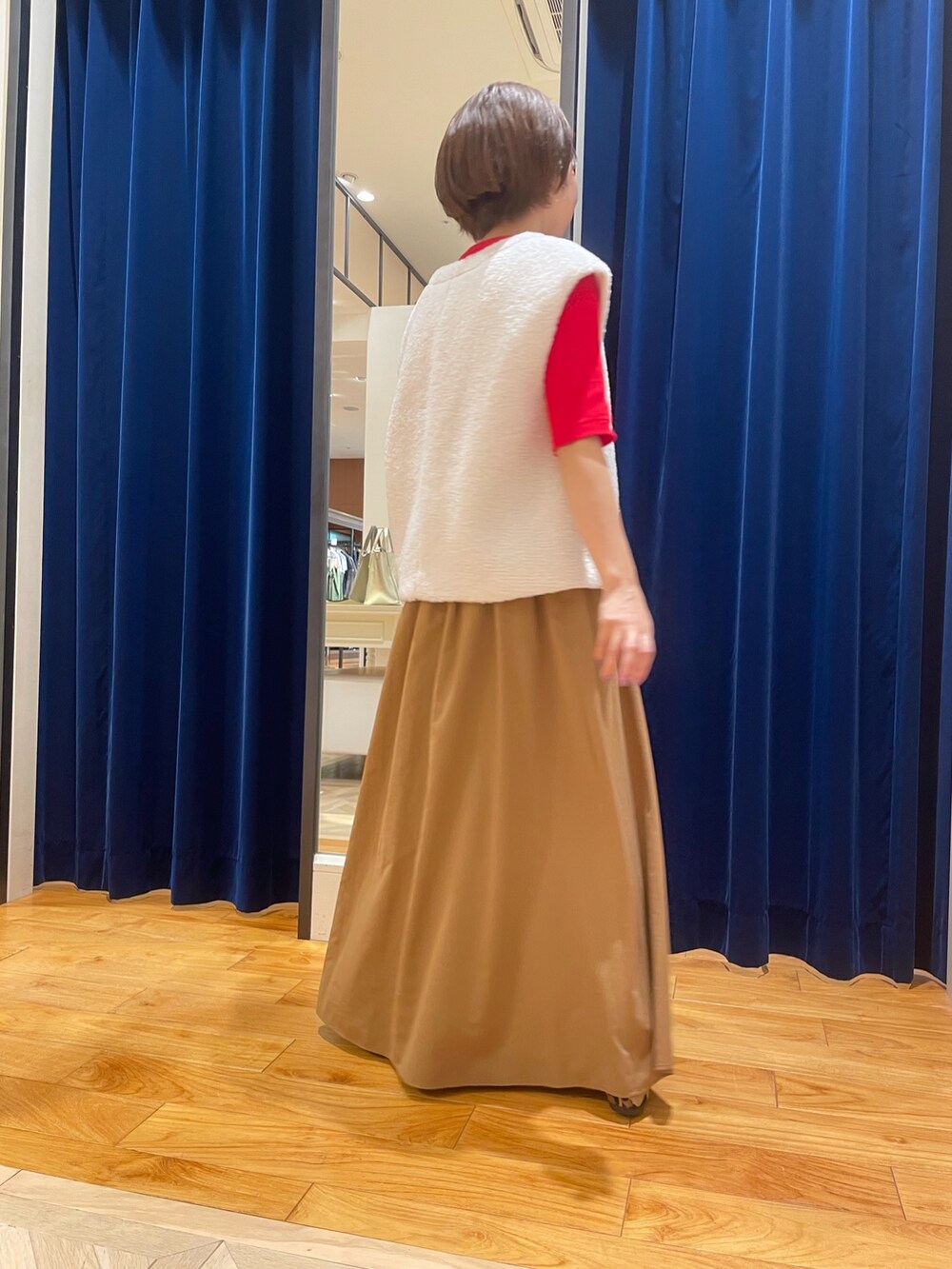 ホワイト系のベスト、イエロー系のスカート、レッド系のTシャツ/カットソーを着用したレディースの夏コーディネートの4枚目の写真