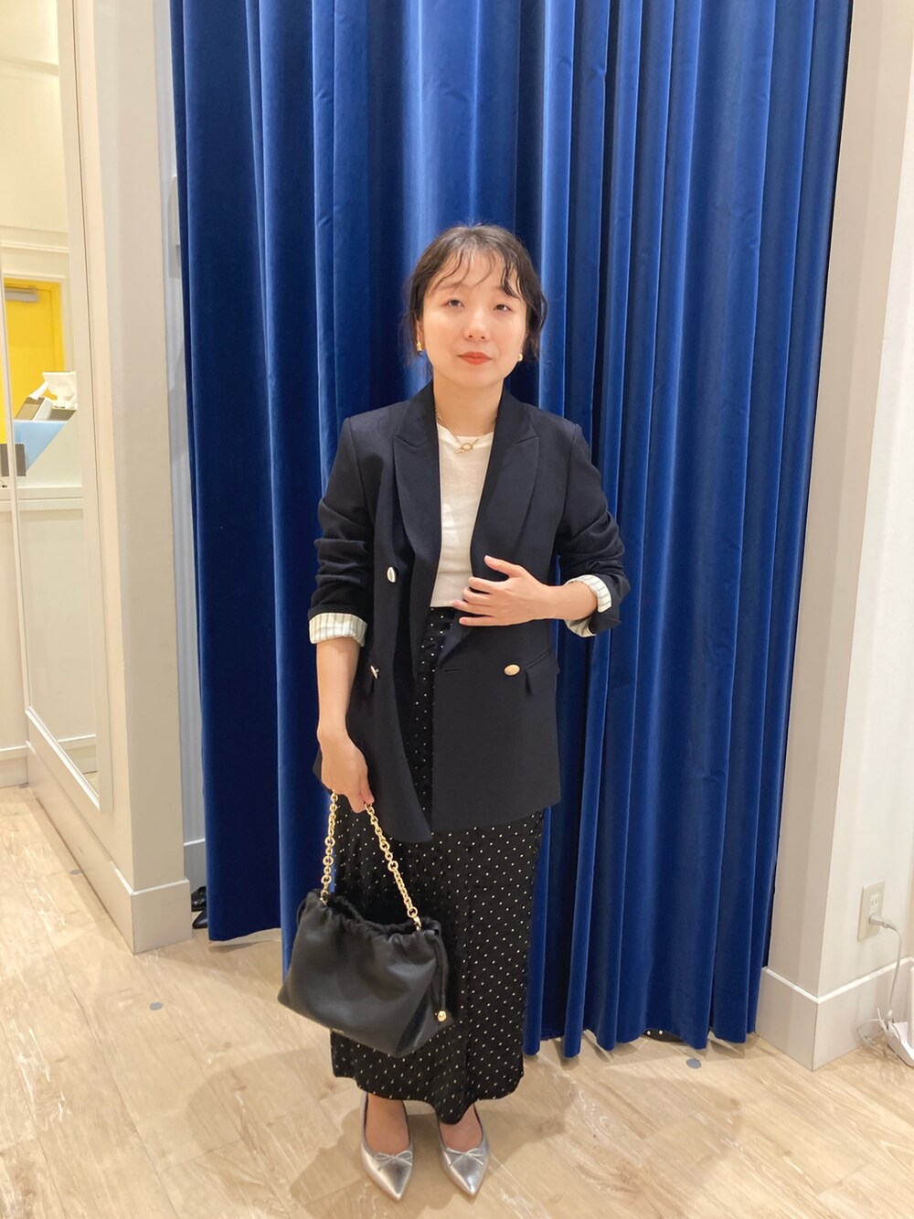 ブルー系のテーラードジャケット、ブラック系のスカート、ホワイト系のTシャツ/カットソーを着用したレディースの秋コーディネートの5枚目の写真