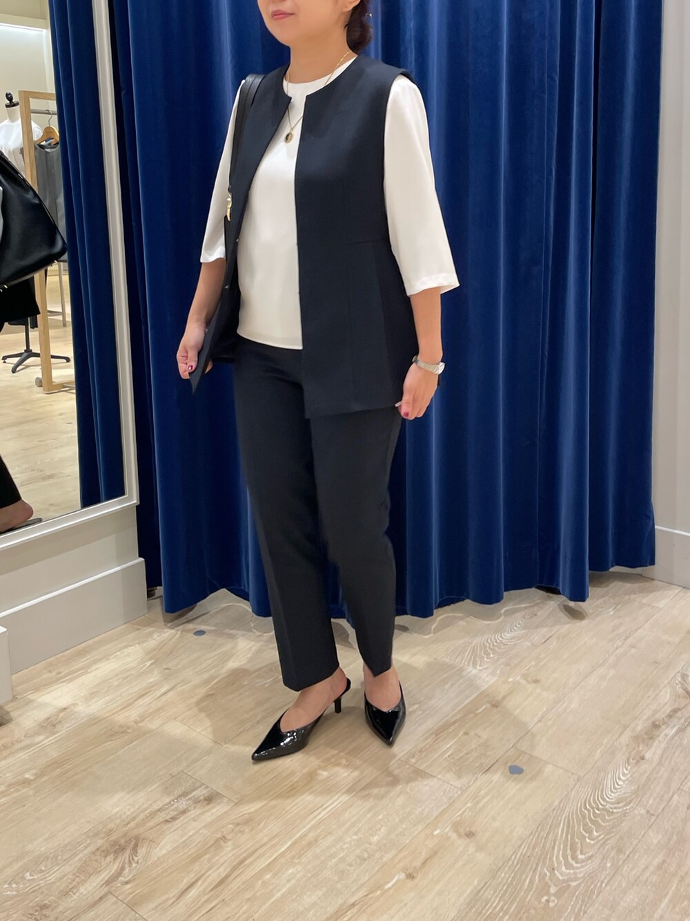 ブルー系のベスト、ブルー系のその他パンツ、ホワイト系のシャツ/ブラウスを着用したレディースの秋コーディネートの4枚目の写真