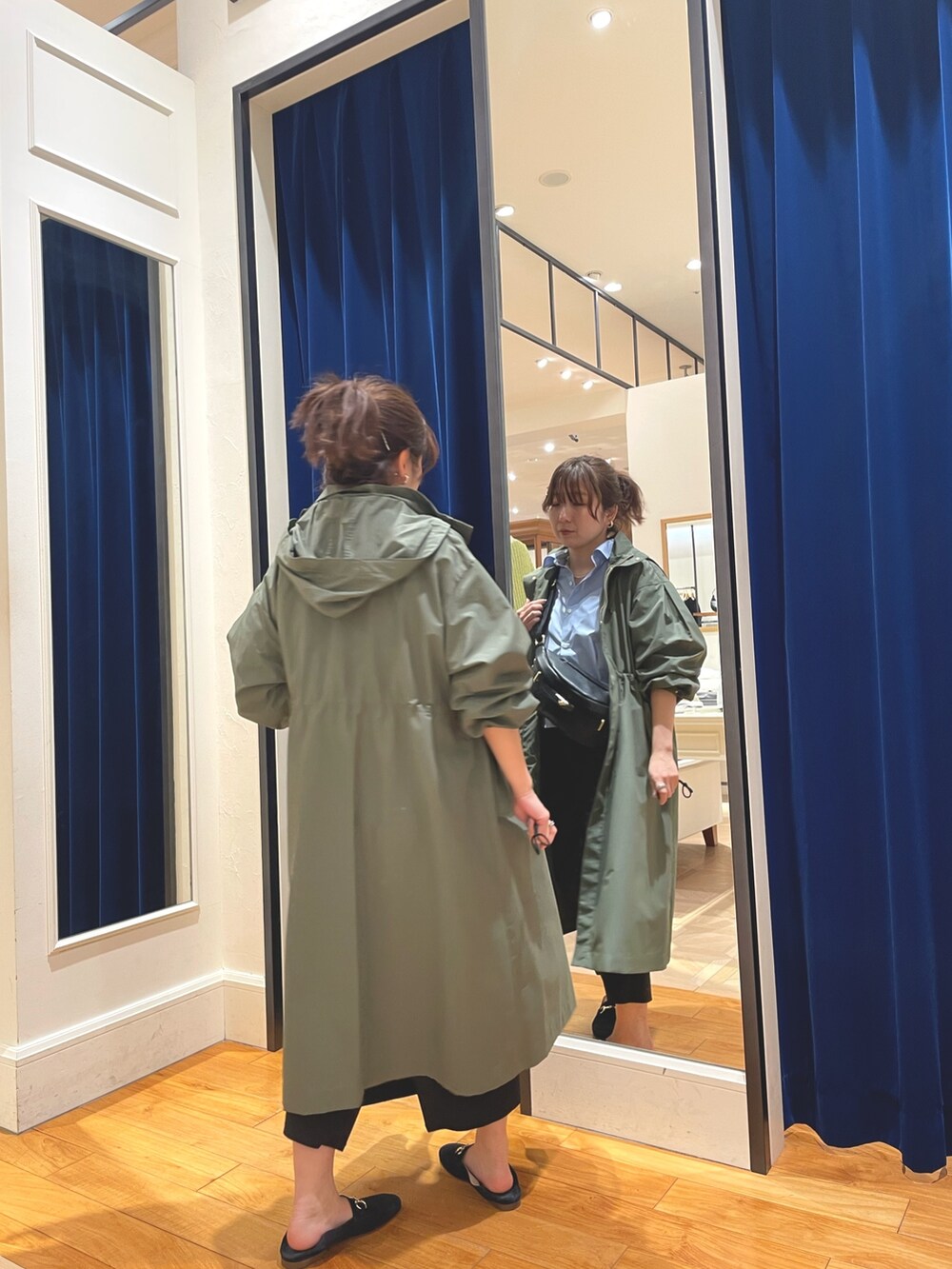 グリーン系のその他アウター、ブラック系のスカート、ブルー系のシャツ/ブラウスを着用したレディースの春コーディネートの3枚目の写真