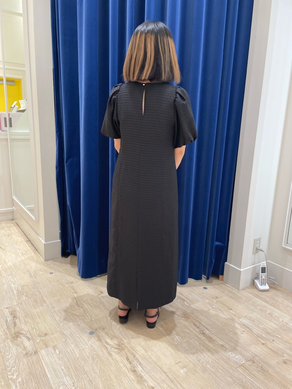 ブラック系のワンピースを着用したレディースの春コーディネートの2枚目の写真