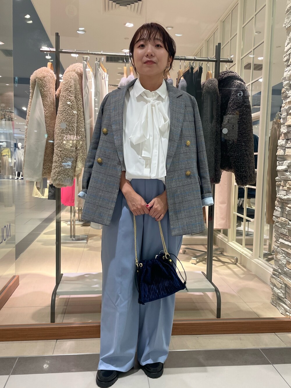 グレー系のテーラードジャケット、ブルー系のその他パンツ、ホワイト系のシャツ/ブラウスを着用したレディースの秋コーディネートの2枚目の写真