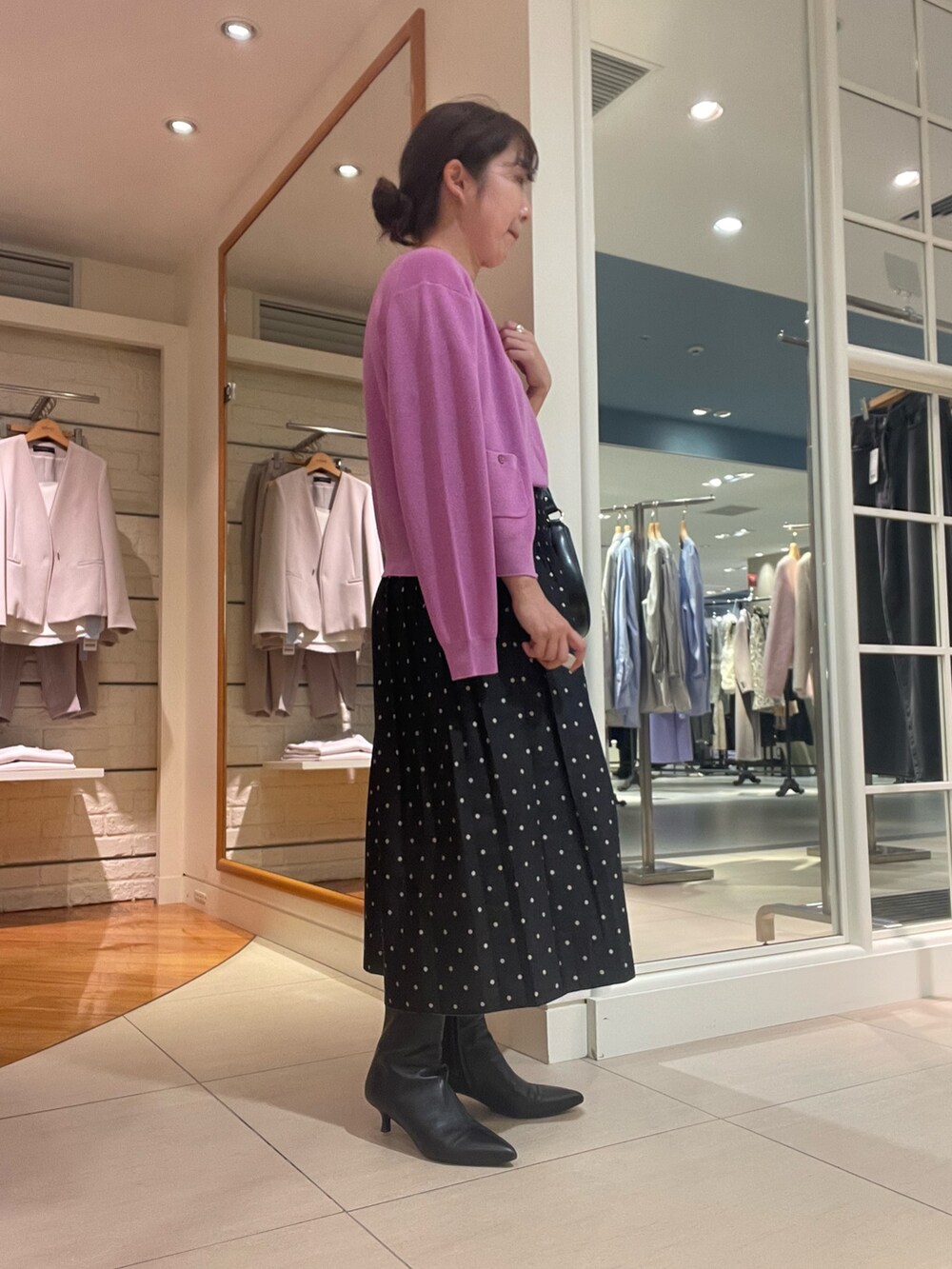 ピンク系のカーディガン/ボレロ、ピンク系のニット/セーター、ブラック系のスカートを着用したレディースの秋コーディネートの3枚目の写真