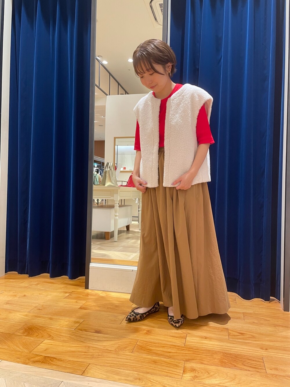 ホワイト系のベスト、イエロー系のスカート、レッド系のTシャツ/カットソーを着用したレディースの夏コーディネートの2枚目の写真