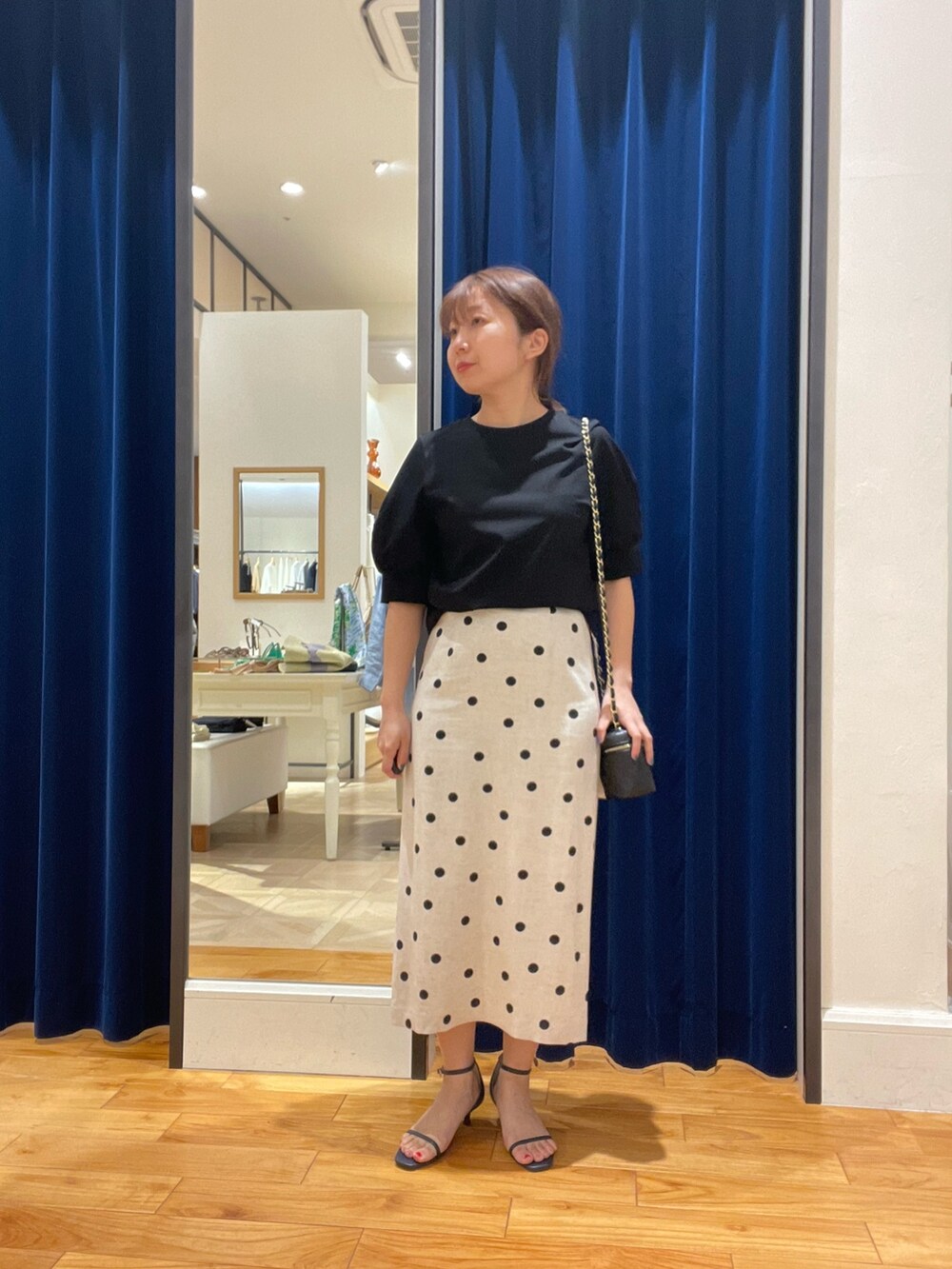 ブラック系のTシャツ/カットソー、ブラック系のスカートを着用したレディースの春コーディネートの2枚目の写真