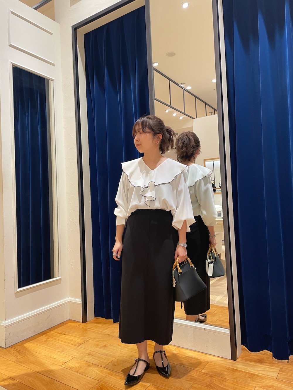 ホワイト系のシャツ/ブラウス、ブラック系のスカート、ゴールド系のパンプスを着用したレディースの春コーディネートの3枚目の写真