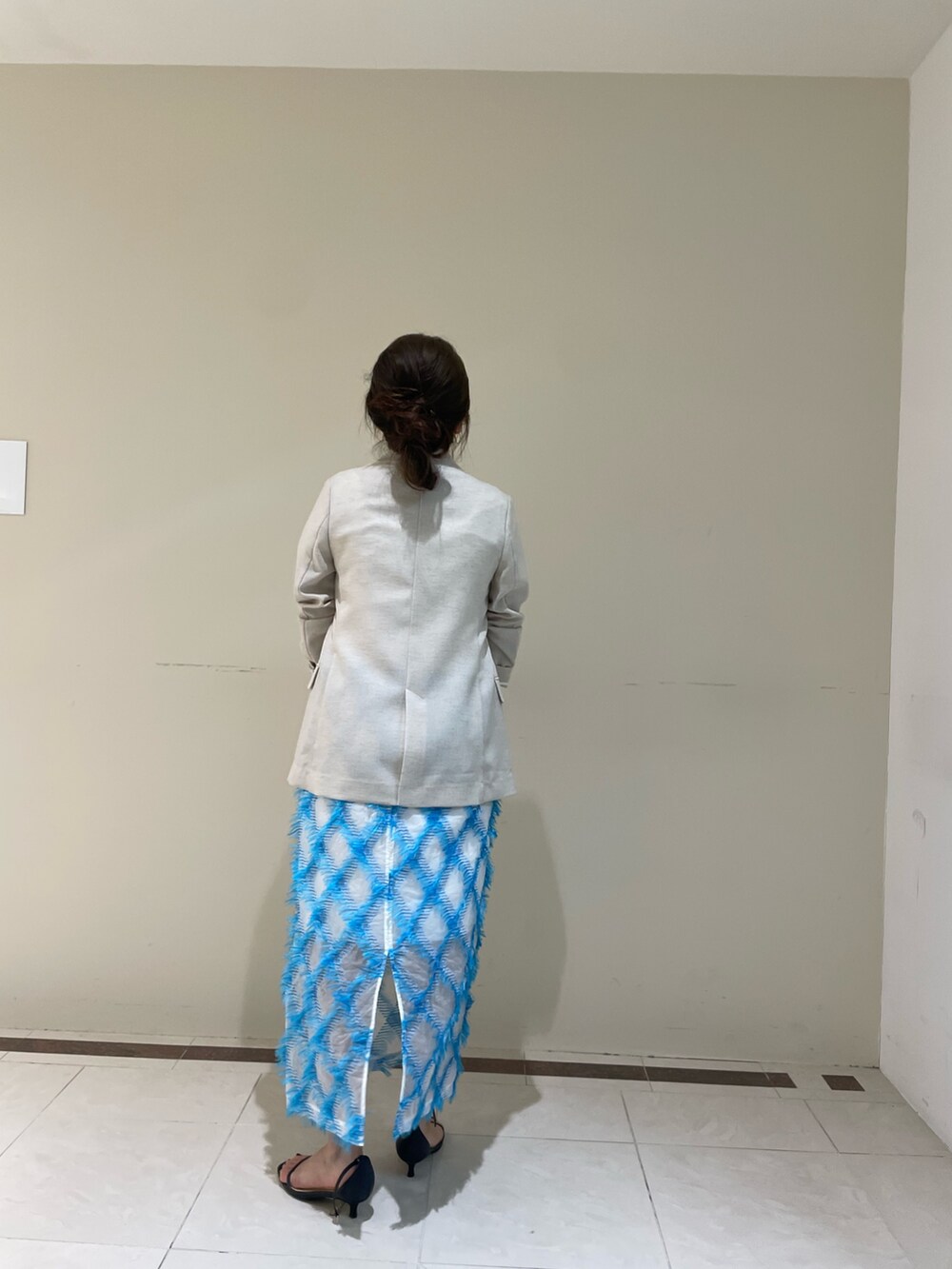 ベージュ系のテーラードジャケット、ブルー系のスカート、ホワイト系のTシャツ/カットソーを着用したレディースの春コーディネートの8枚目の写真