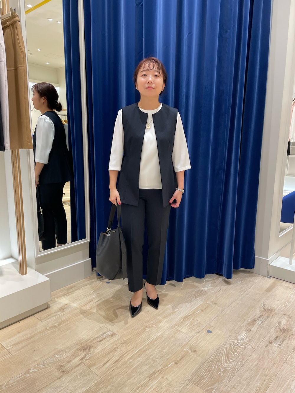 ブルー系のベスト、ブルー系のその他パンツ、ホワイト系のシャツ/ブラウスを着用したレディースの秋コーディネートの2枚目の写真