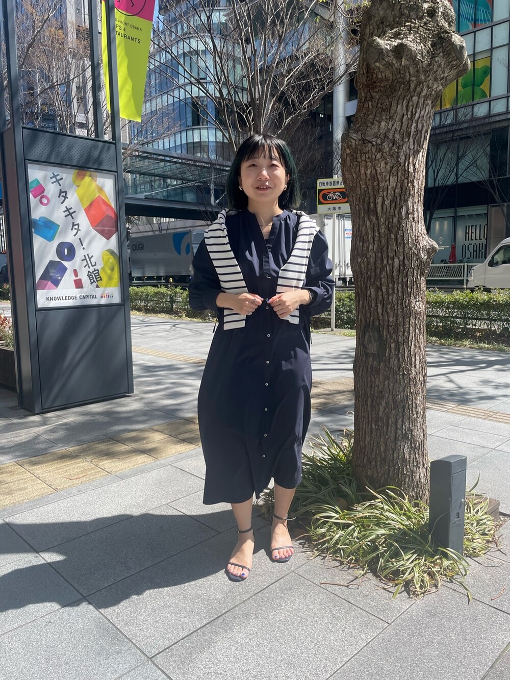 ブルー系のワンピース、ホワイト系のカーディガン/ボレロを着用したレディースの春コーディネートの2枚目の写真