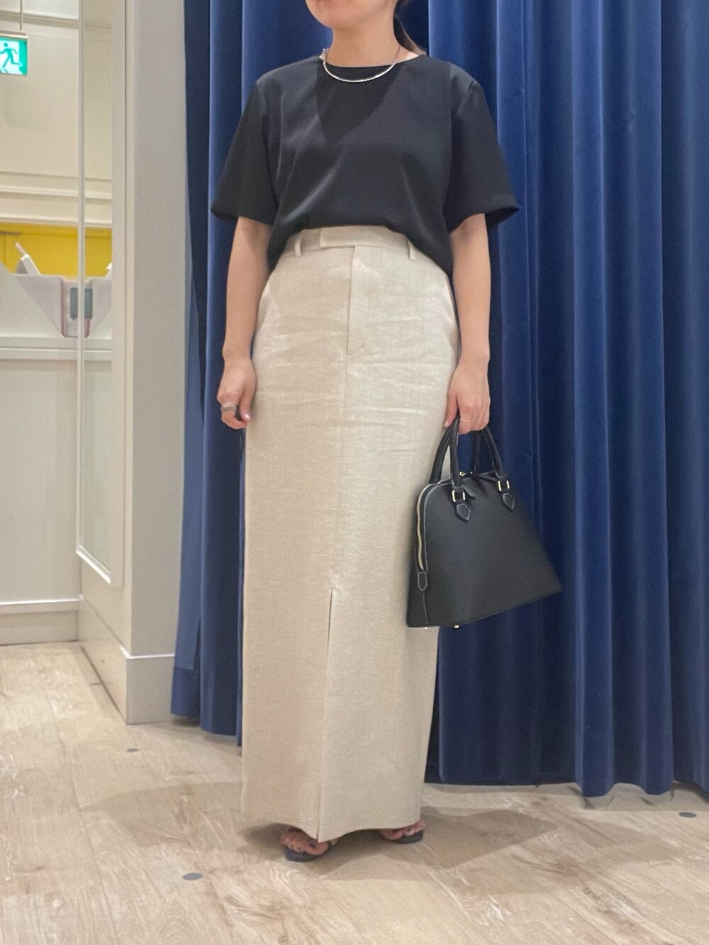 ベージュ系のスカート、ブラック系のシャツ/ブラウス、ブラック系のボストンバッグを着用したレディースの春コーディネートの2枚目の写真