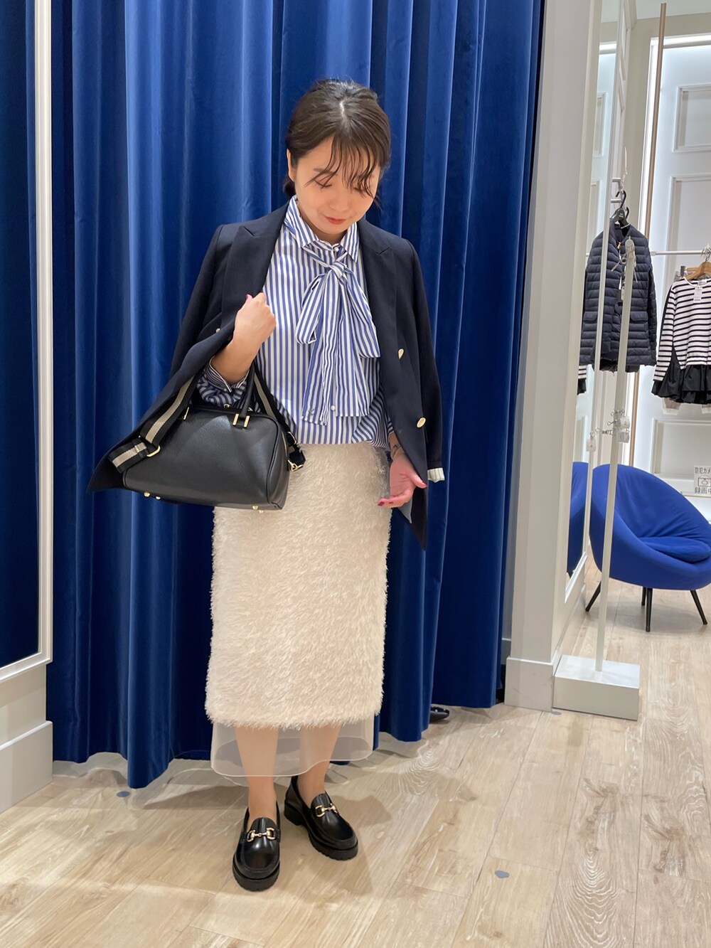 ブルー系のシャツ/ブラウス、ブルー系のスカート、ブルー系のテーラードジャケットを着用したレディースの秋コーディネートの2枚目の写真