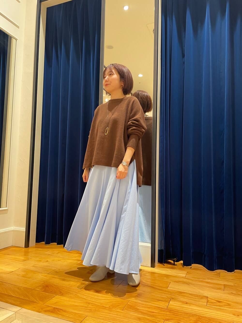 ブラウン系のニット/セーター、ブルー系のスカートを着用したレディースの冬コーディネートの2枚目の写真