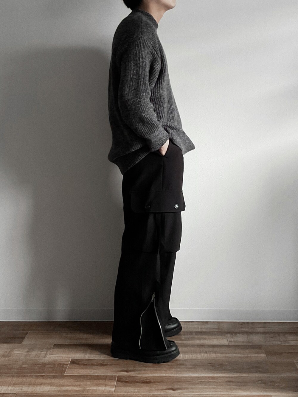 グレー系のニット/セーター、ブラック系のカーゴパンツ、ホワイト系のその他を着用したメンズの秋コーディネートの3枚目の写真