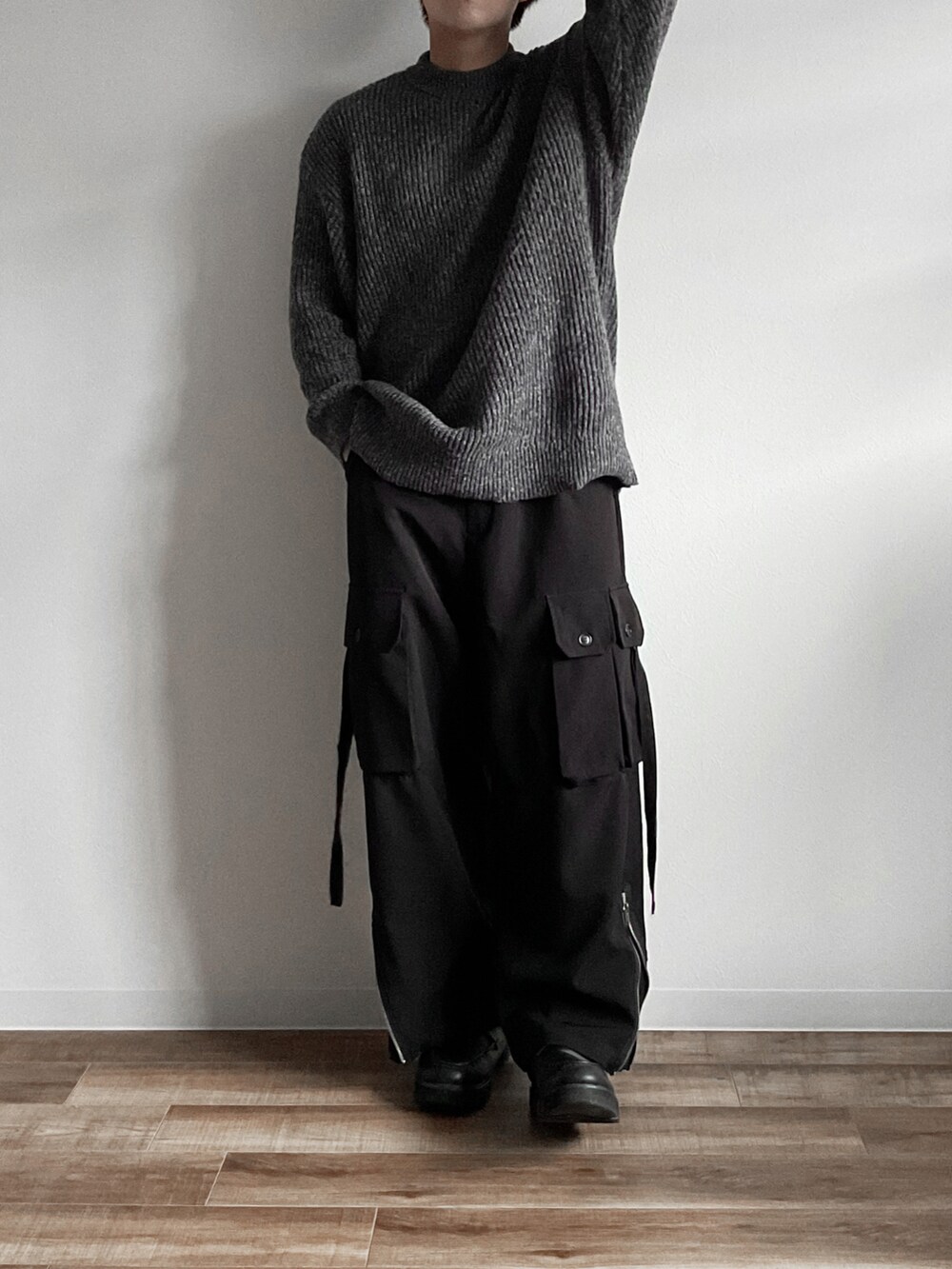 グレー系のニット/セーター、ブラック系のカーゴパンツ、ホワイト系のその他を着用したメンズの秋コーディネートの2枚目の写真