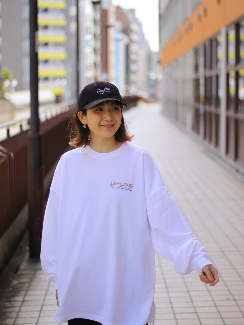 ホワイト系のTシャツ/カットソー、ブラック系のその他パンツ、ベージュ系のスニーカーを着用したレディースの春コーディネートの2枚目の写真