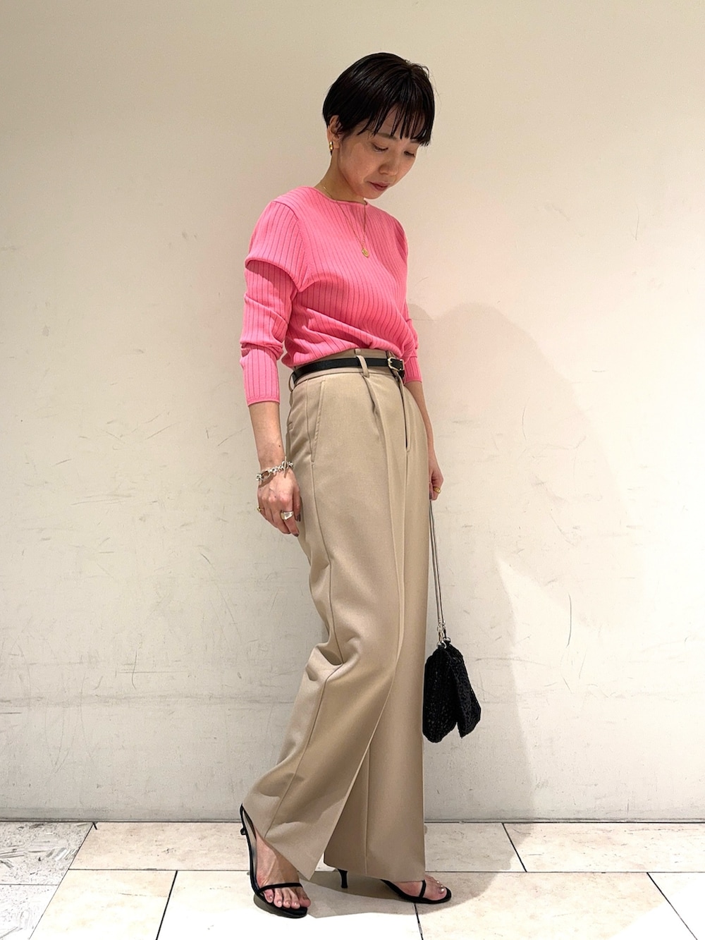ピンク系のニット/セーター、ベージュ系のその他パンツ、ブラック系のショルダーバッグを着用したレディースの冬コーディネートの3枚目の写真