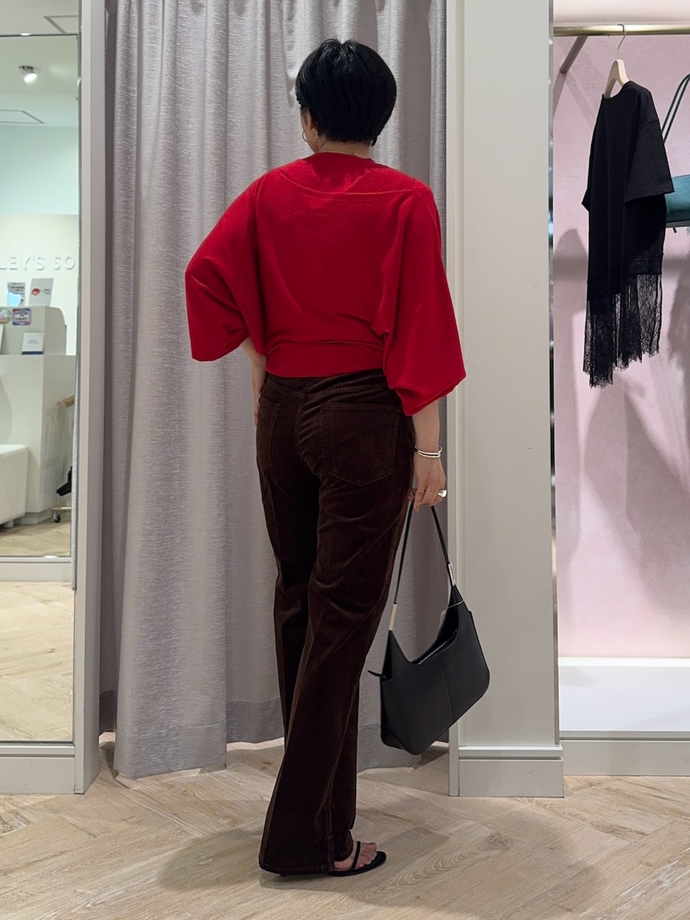 レッド系のニット/セーター、ブラウン系のその他パンツ、ブラック系のショルダーバッグを着用したレディースの夏コーディネートの5枚目の写真