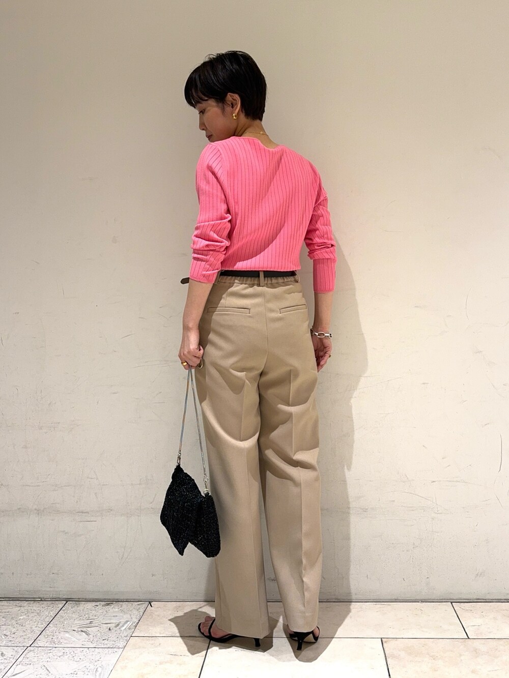 ピンク系のニット/セーター、ベージュ系のその他パンツ、ブラック系のショルダーバッグを着用したレディースの冬コーディネートの4枚目の写真