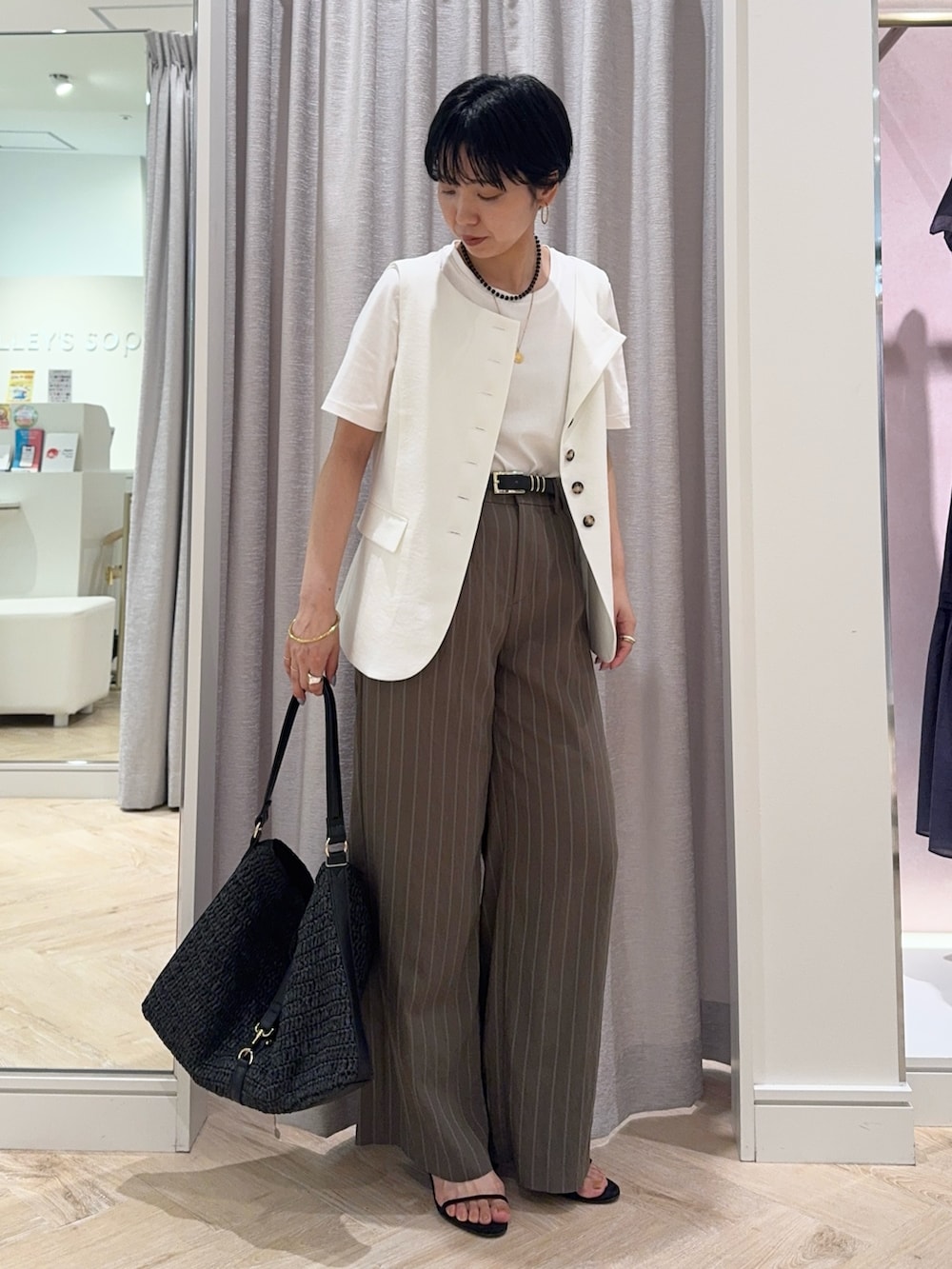 ブラック系のショルダーバッグ、グリーン系のその他パンツ、ホワイト系のTシャツ/カットソーを着用したレディースの夏コーディネートの4枚目の写真