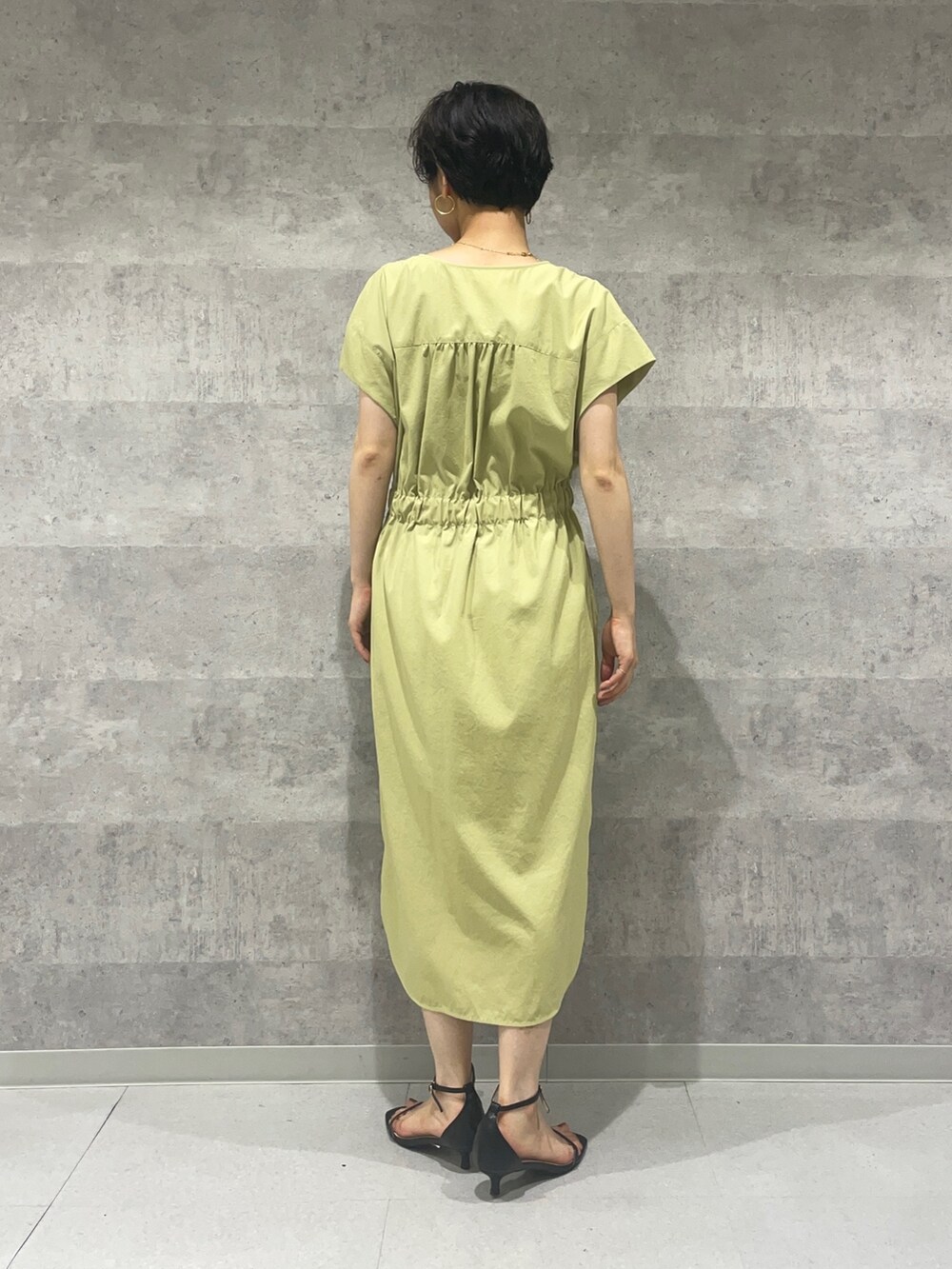 ブラック系のカーディガン/ボレロ、ブラック系のサンダル、イエロー系のワンピースを着用したレディースの夏コーディネートの5枚目の写真