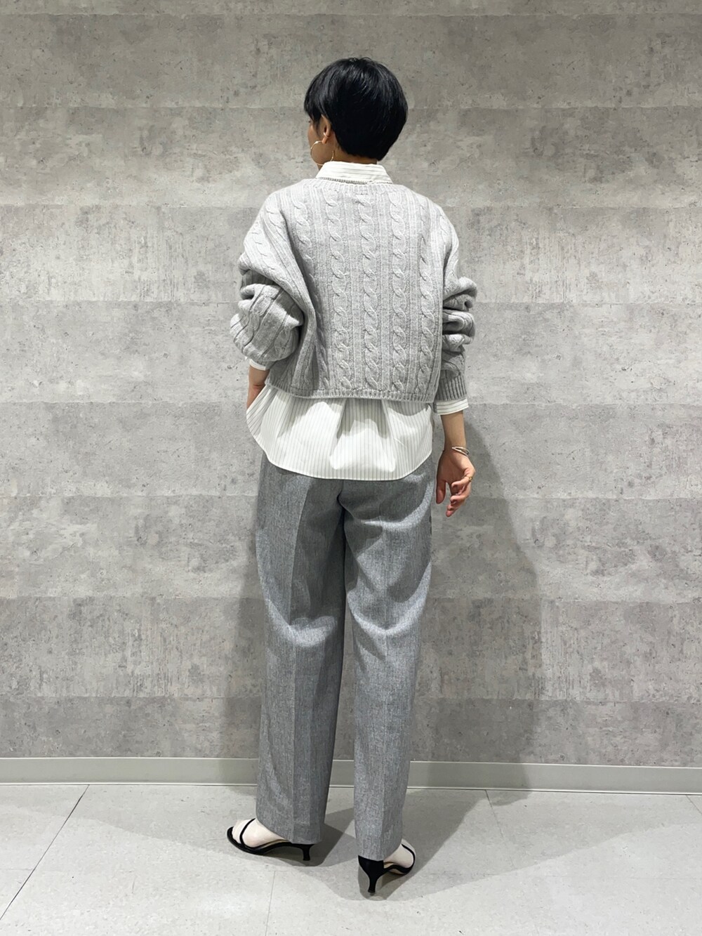 グレー系のその他パンツ、ホワイト系のシャツ/ブラウス、グレー系のニット/セーターを着用したレディースの秋コーディネートの4枚目の写真