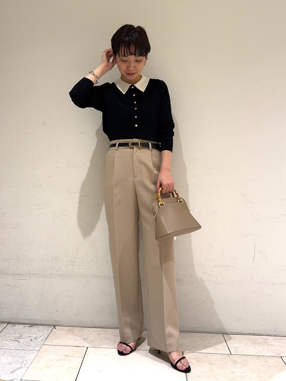 ブラック系のニット/セーター、ベージュ系のその他パンツ、ベージュ系のショルダーバッグを着用したレディースの冬コーディネートの5枚目の写真