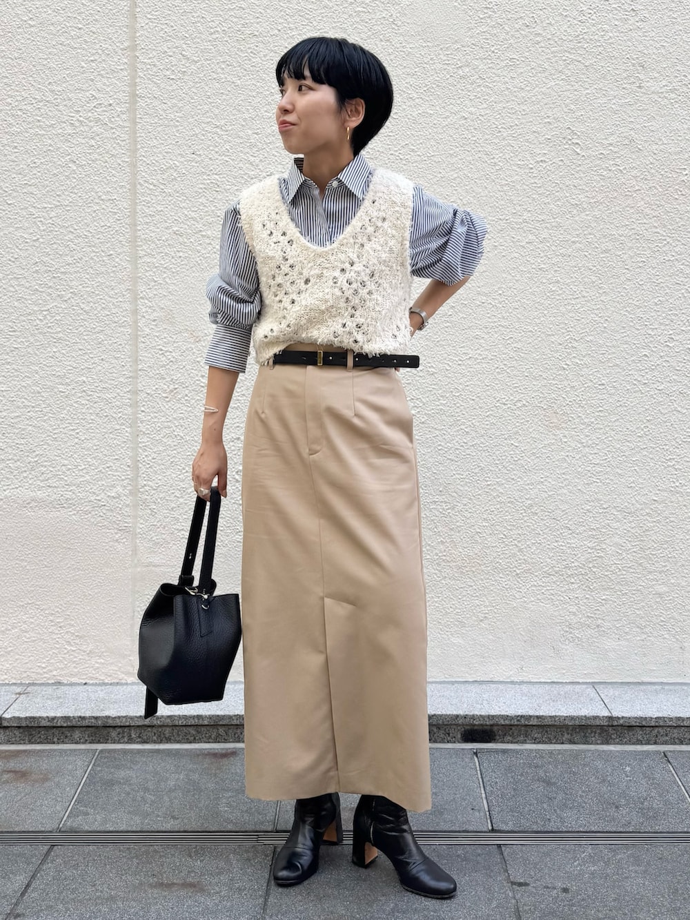 ブルー系のシャツ/ブラウス、ホワイト系のベスト、ベージュ系のスカートを着用したレディースの秋コーディネートの4枚目の写真