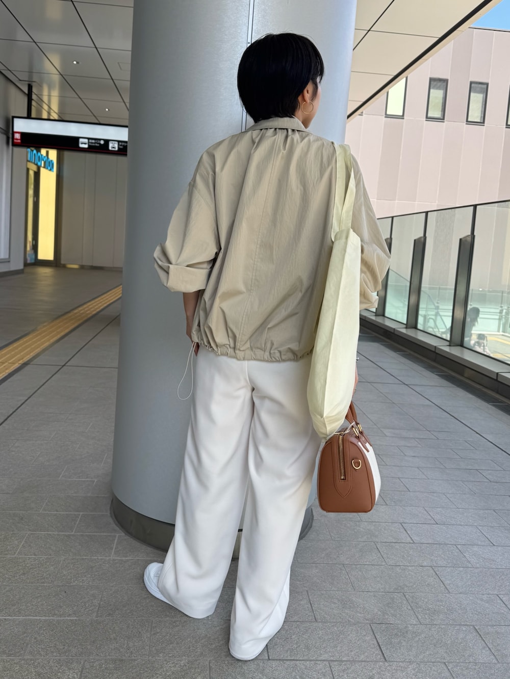 ベージュ系のニット/セーター、ベージュ系のブルゾン、ブラウン系のボストンバッグを着用したレディースの春コーディネートの5枚目の写真