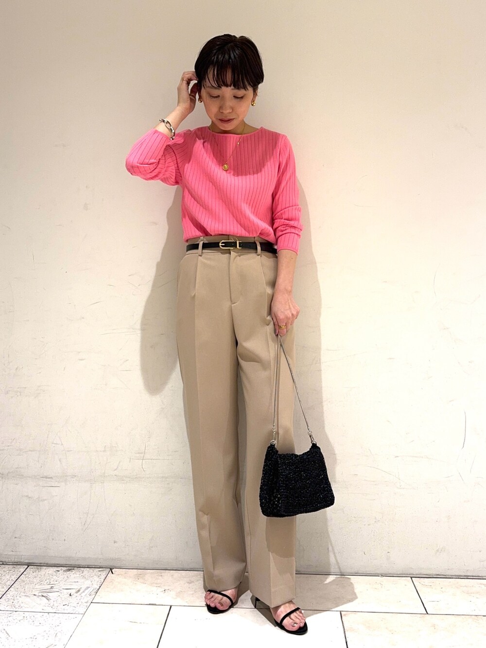 ピンク系のニット/セーター、ベージュ系のその他パンツ、ブラック系のショルダーバッグを着用したレディースの冬コーディネートの2枚目の写真