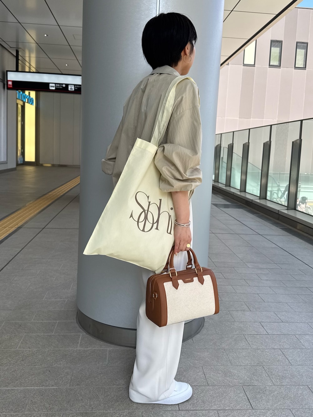 ベージュ系のニット/セーター、ベージュ系のブルゾン、ブラウン系のボストンバッグを着用したレディースの春コーディネートの4枚目の写真