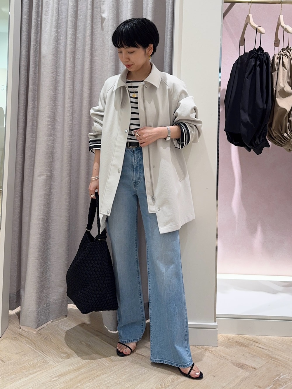 ブラック系のTシャツ/カットソー、ベージュ系のステンカラーコート、ブラック系のショルダーバッグを着用したレディースの春コーディネートの5枚目の写真