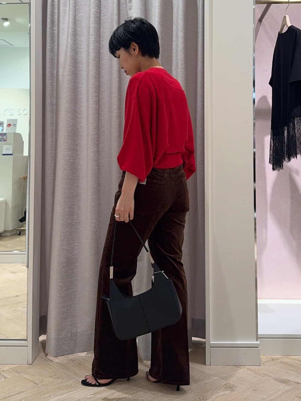 レッド系のニット/セーター、ブラウン系のその他パンツ、ブラック系のショルダーバッグを着用したレディースの夏コーディネートの3枚目の写真