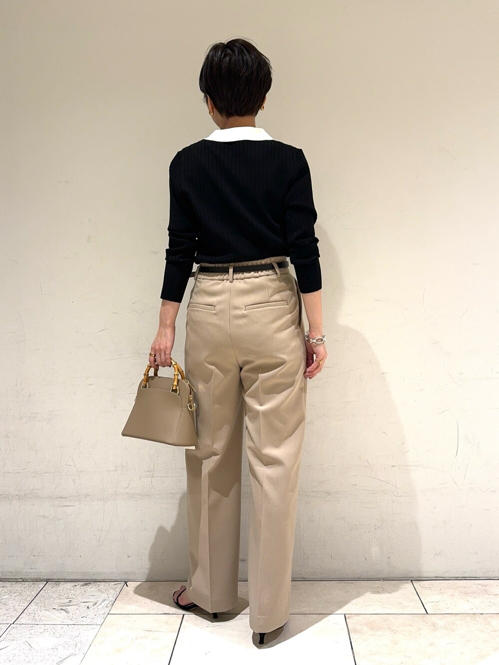 ブラック系のニット/セーター、ベージュ系のその他パンツ、ベージュ系のショルダーバッグを着用したレディースの冬コーディネートの4枚目の写真