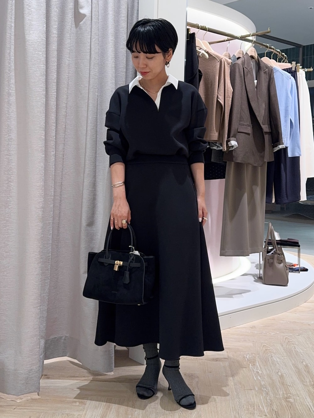 ブラック系のTシャツ/カットソー、ブラック系のトートバッグ、ブラック系のスカートを着用したレディースの秋コーディネートの4枚目の写真