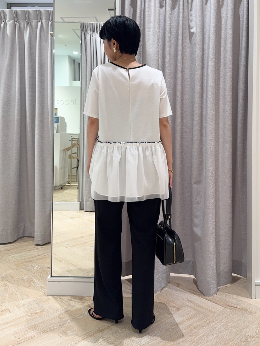 ホワイト系のTシャツ/カットソー、ブラック系のボストンバッグ、ブラック系のその他パンツを着用したレディースの夏コーディネートの3枚目の写真